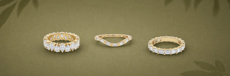 Three lab-grown diamond eternity bands in yellow gold — pear cut shared prong full eternity band, curved baguette chevron wedding band, and alternating baguette and round brilliant half eternity band on olive green background
